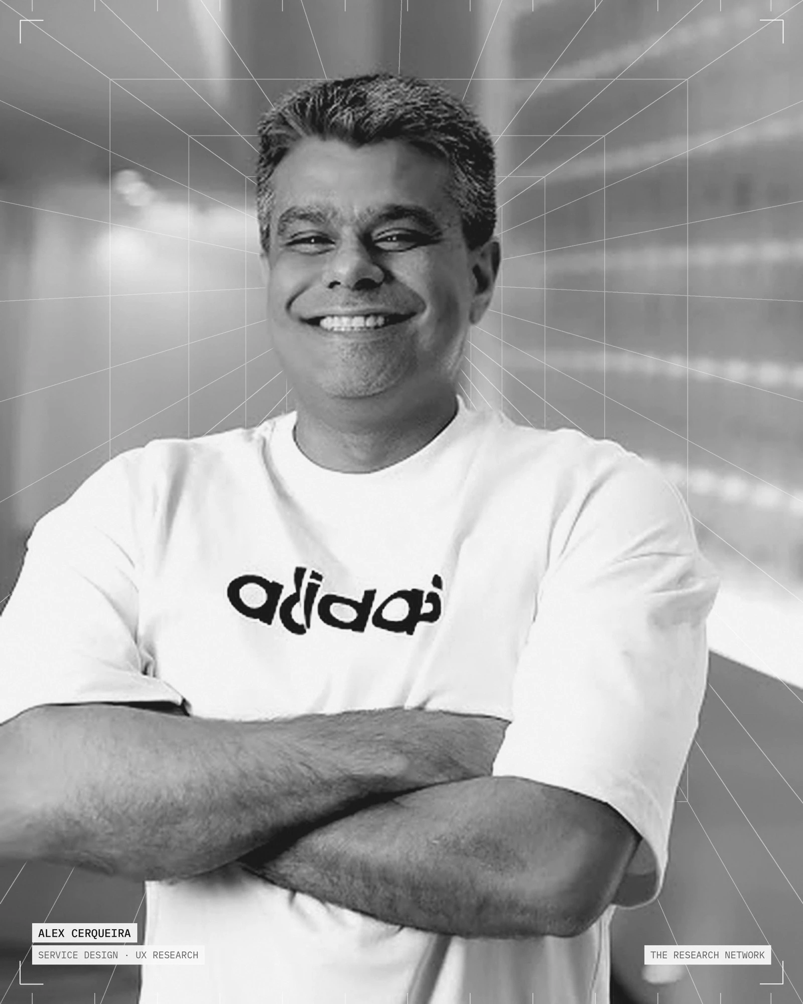Retrato de Alex Cerqueira em preto e branco, sorrindo, de braços cruzados